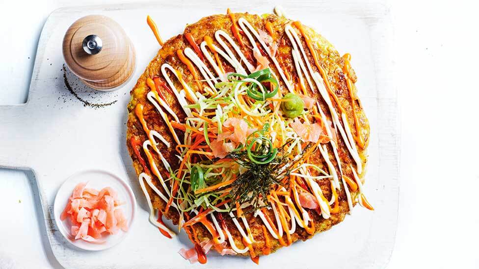 Pork and cabbage Japanese-style pancake dressed with traditional mayonnaise and sriracha mayonnaise.