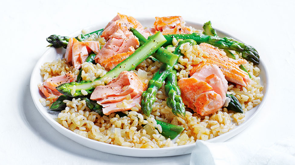 Brown rice pilaf topped with salmon and asparagus