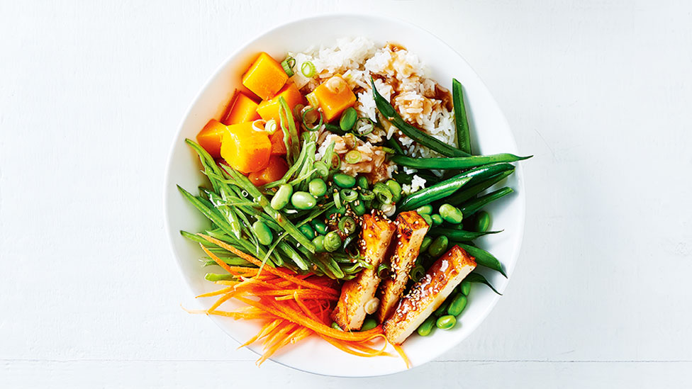 Satay tofu and coconut rice salad bowl with pumpkin and beans