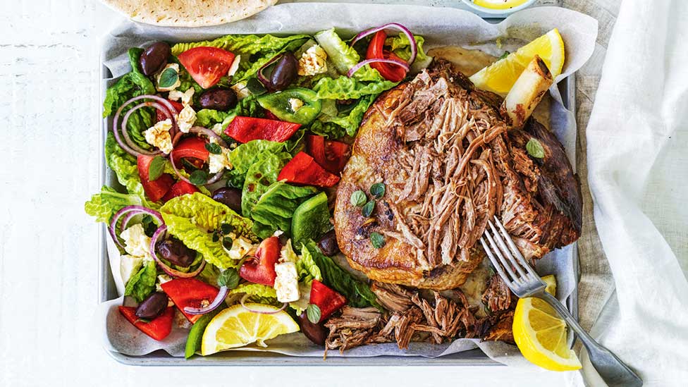 Greek-style lamb chops with salads and lemon wedges