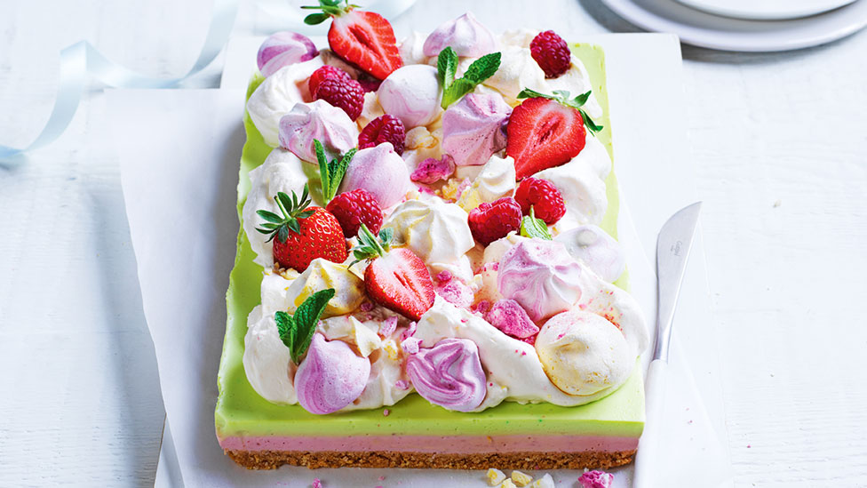 Smashed pavlova slice decorated with strawberries, cream and meringue kisses. 