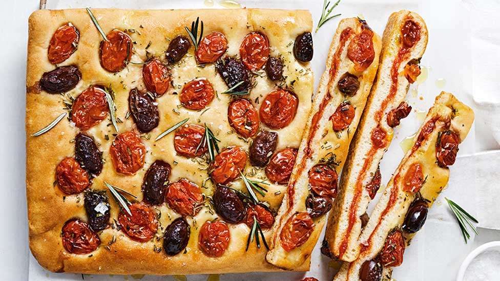 Stuffed focaccia with tomato and olive cut into slices