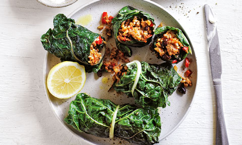 Five silverbeet & black bean burritos on a plate with lemon on the side.