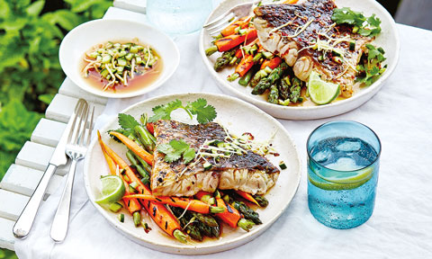 Two bowls of bbq chilli barramundi with carrot and asparagus, served with ginger and cucumber dressing