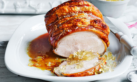 A sliced rump of roast pork with crackling, served with apple jelly gems