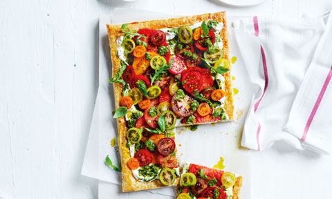 A tomato ricotta tart with sprigs of fresh herbs