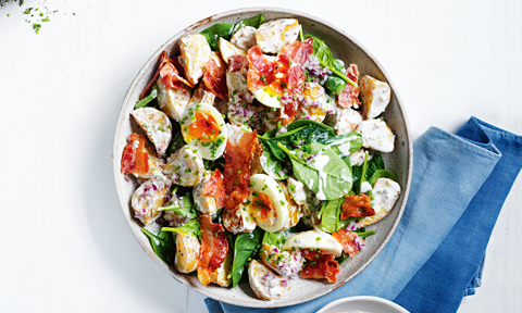 A warm potato salad in a bowl served with creamy dressing