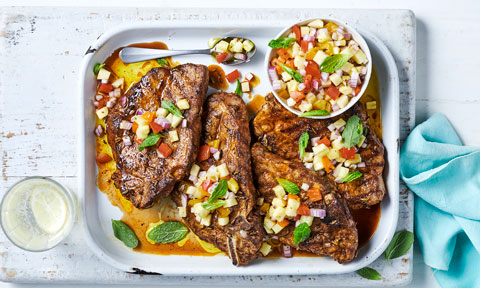 Four BBQ pork chops with pineapple salsa on a baking tray