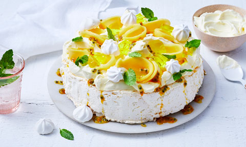 Tropical pavlova topped with mango, jelly and meringues