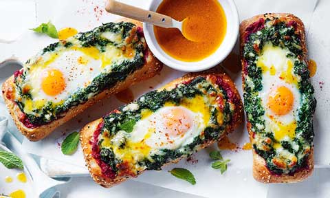 Crusty pide bread topped with spinach and eggs