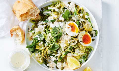 Green salad with egg cut in half and shredded brussel sprouts