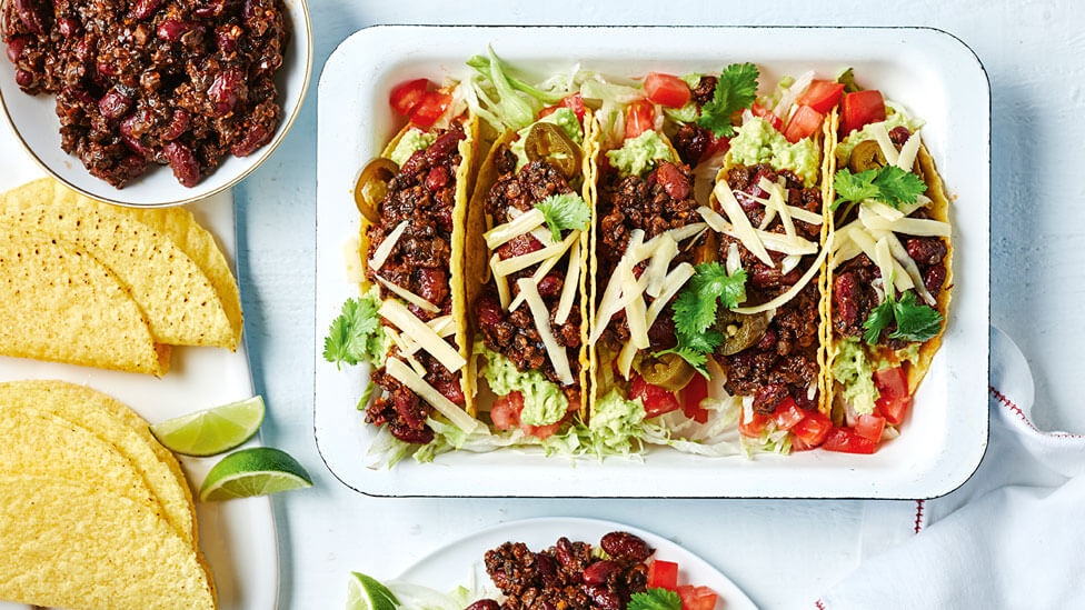 Mexican-style mushroom mince tacos in a dish with taco shells and extra mince on the side