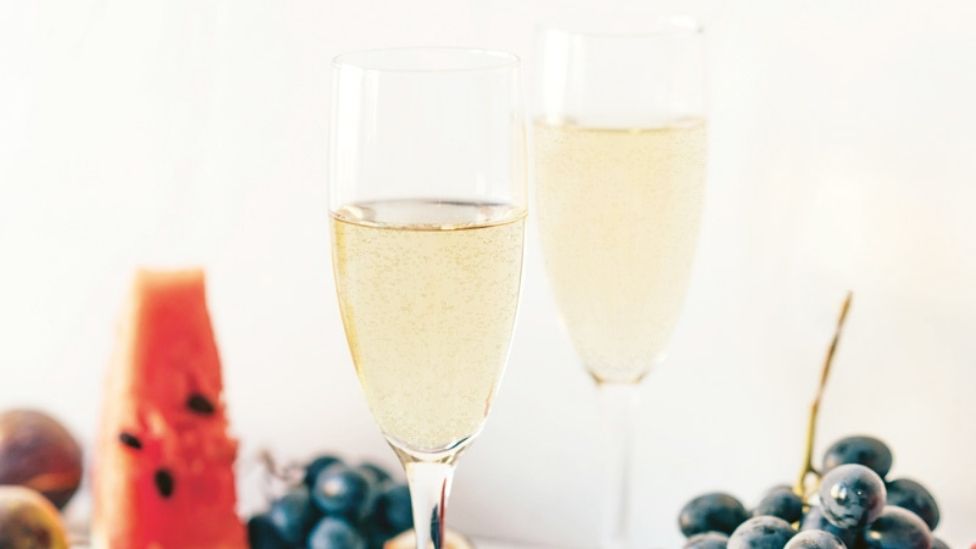 Two glasses of champagne served with fruit