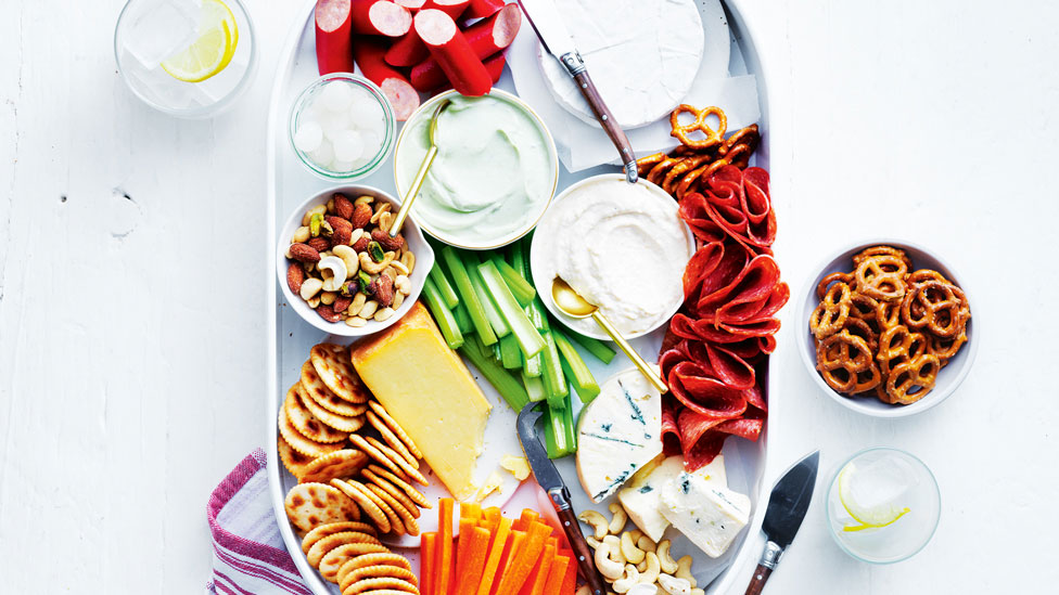 A mixed cheeseboard with assorted condiments 