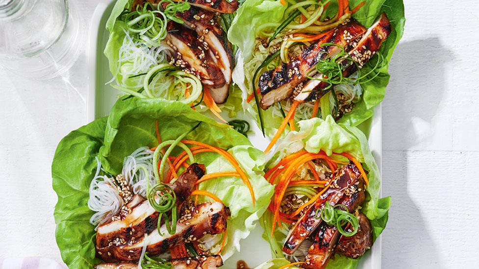 Four cups of lettuce filled with korean styled bbq chicken