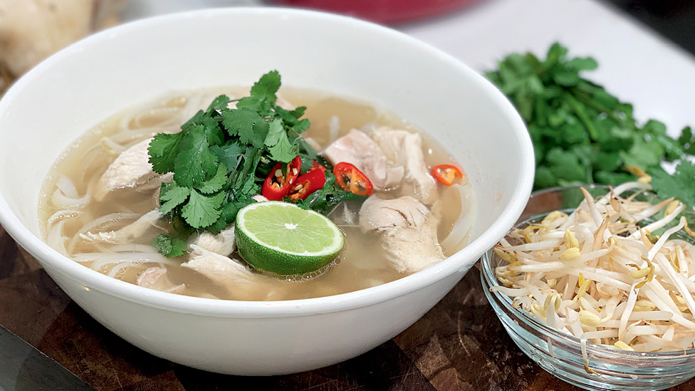 Chicken pho with coriander, half a lime and spicy chilli