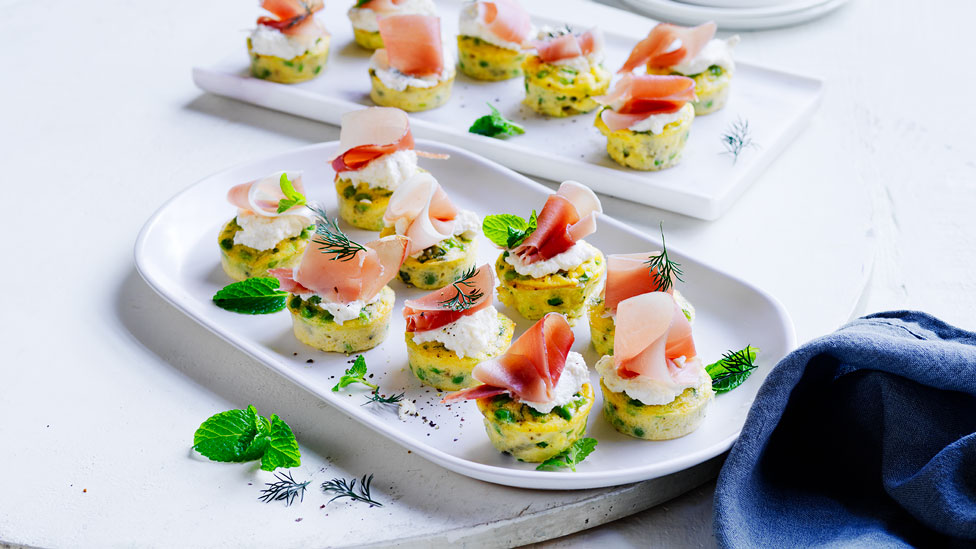 Several mini pea frittatas with ricotta, mint and prosciutto on a dish.