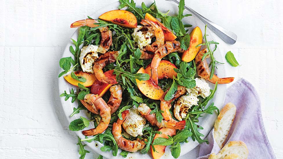 Prosciutto-wrapped prawn and peach salad on a dish