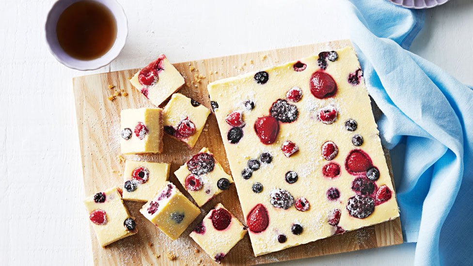 Slices of condensed milk cheesecake on a chopping board.