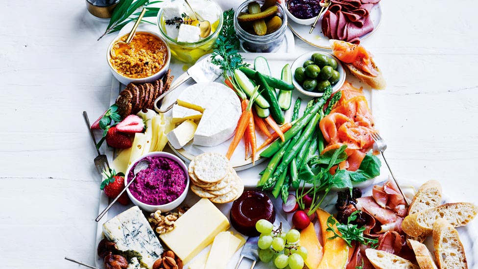 Elegant cheese board with assorted fruit, dips and vegetables.