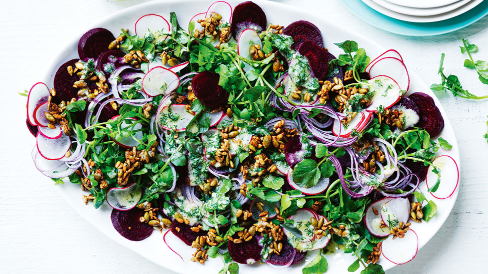 Beetroot, watercress and radish salad with spiced seeds on a plate