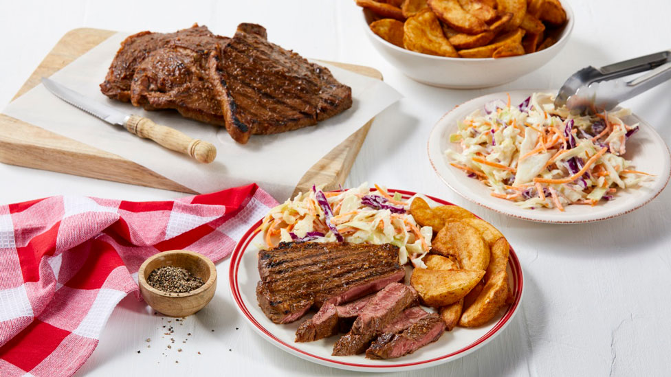 Chargrilled rump steak cut into wedges with coleslaw and wedges
