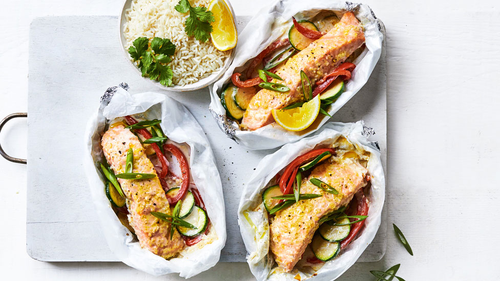 Coconut and lime salmon parcels with rice and lemon wedges