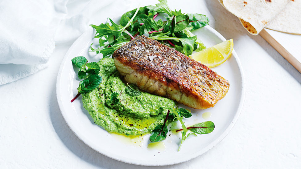 Crispy lemon fish with pea hommus and salad leaves