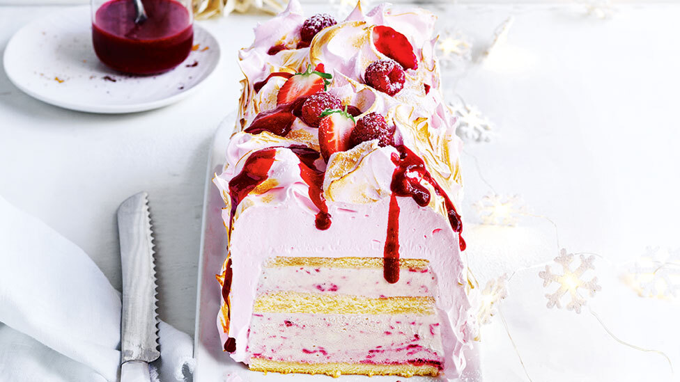 Berry bombe Alaska cake sliced in half.
