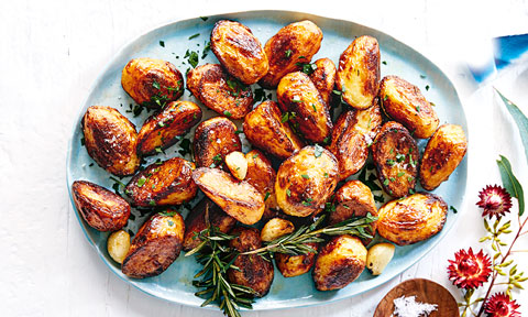 Roast potatoes and rosemary on a dish.