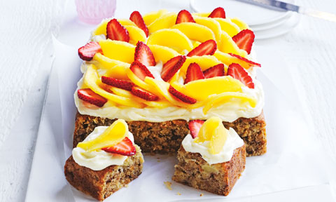 A hummingbird cake topped with mangoes and strawberries