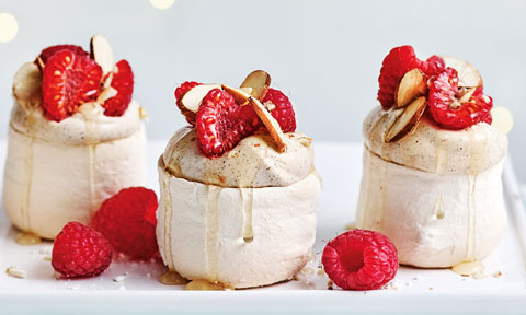 Three mini eggnog pavlovas with rum syrup and raspberry