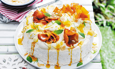 Sliced pineapple on top of a coconut and almond pavlova