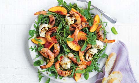 Prosciutto-wrapped prawn and peach salad on a dish
