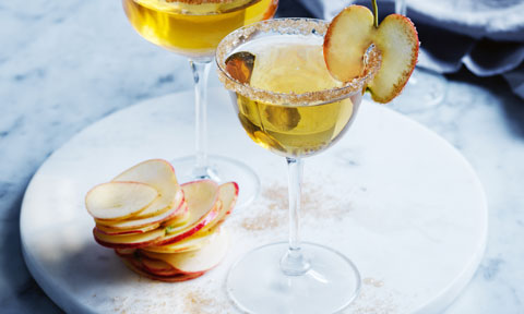 Glass of warm apple pie martini with apple slices.