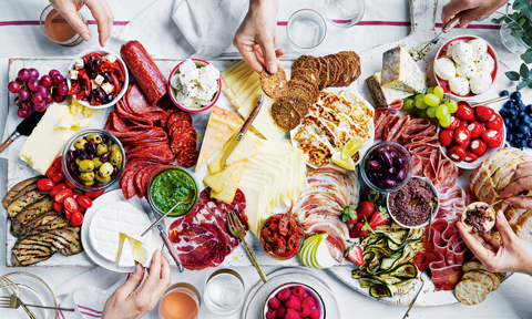 Big cheese board with assorted meats and fruit.