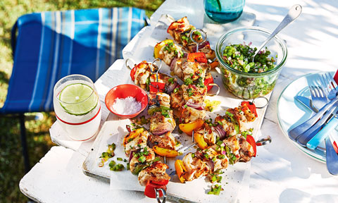 Eight BBQ chicken skewers with green salsa