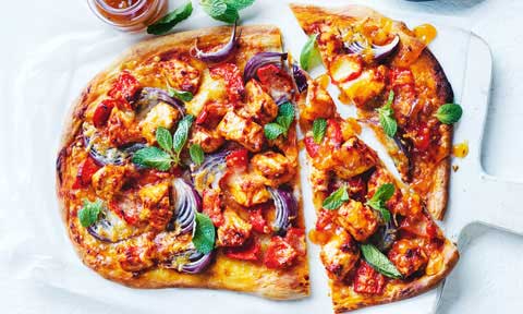 Butter chicken pizza cut into pieces