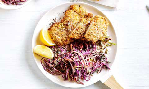 Dukkah-crumbed chicken schnitzel with kaleslaw and lemon wedges