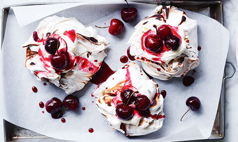 Three black forest mini pavlovas on a tray.