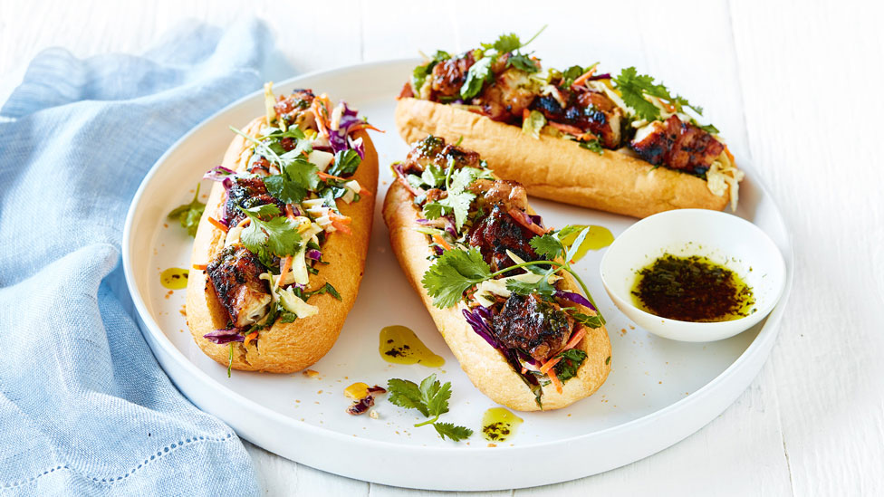 Three honey soy chicken rools with coriander sprigs and salsa verde sauce