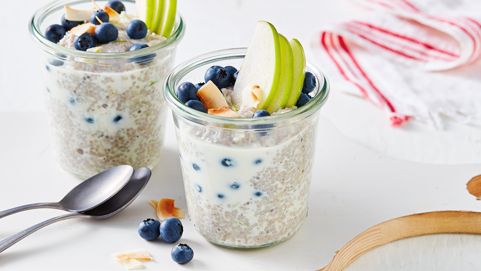 Two blueberry chia pots top with sliced apple and flaked coconut