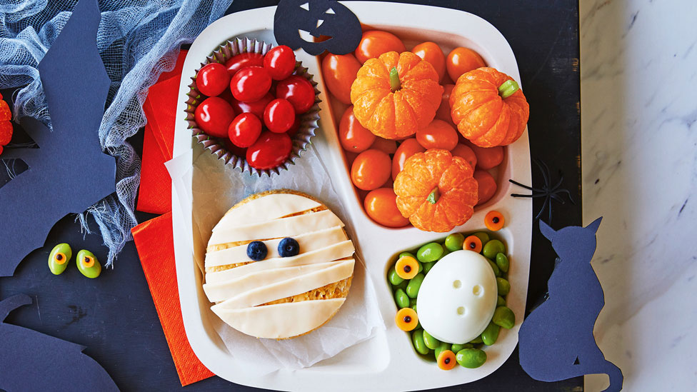 Boo bento box with fruity pumpkins, edamame, mummy sandwich and a hard boiled egg