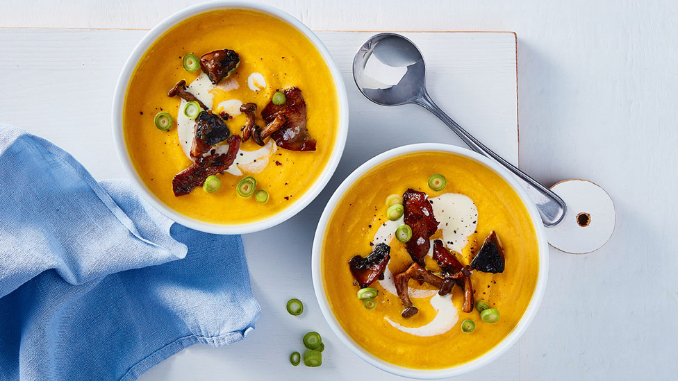 Two bowls of butternut pumpkin soup with sauteed mushrooms