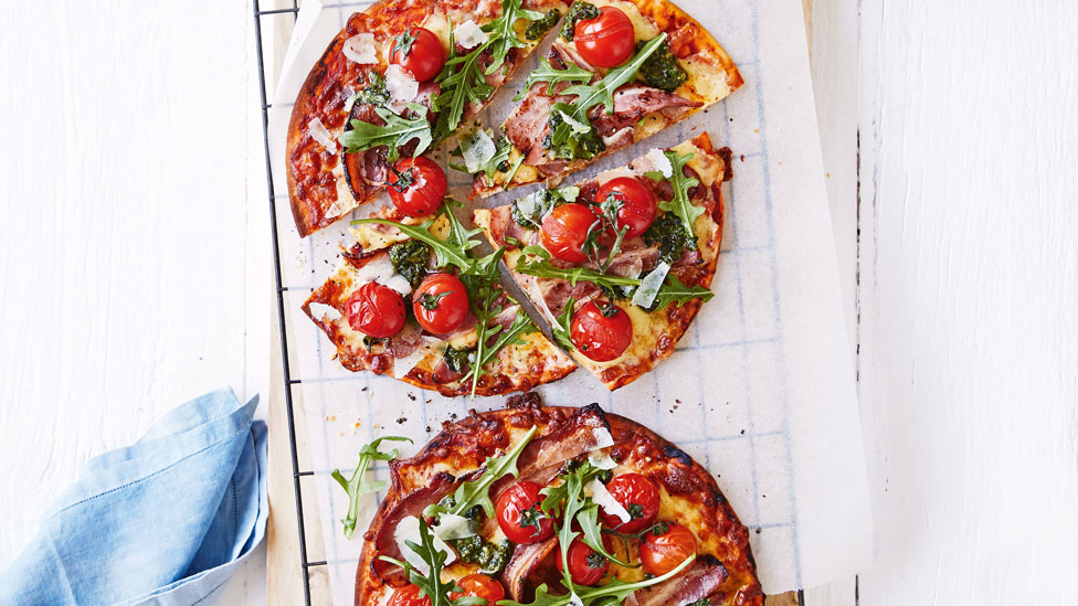 Two easy bacon, lettuce and tomato pizzas cut in pieces