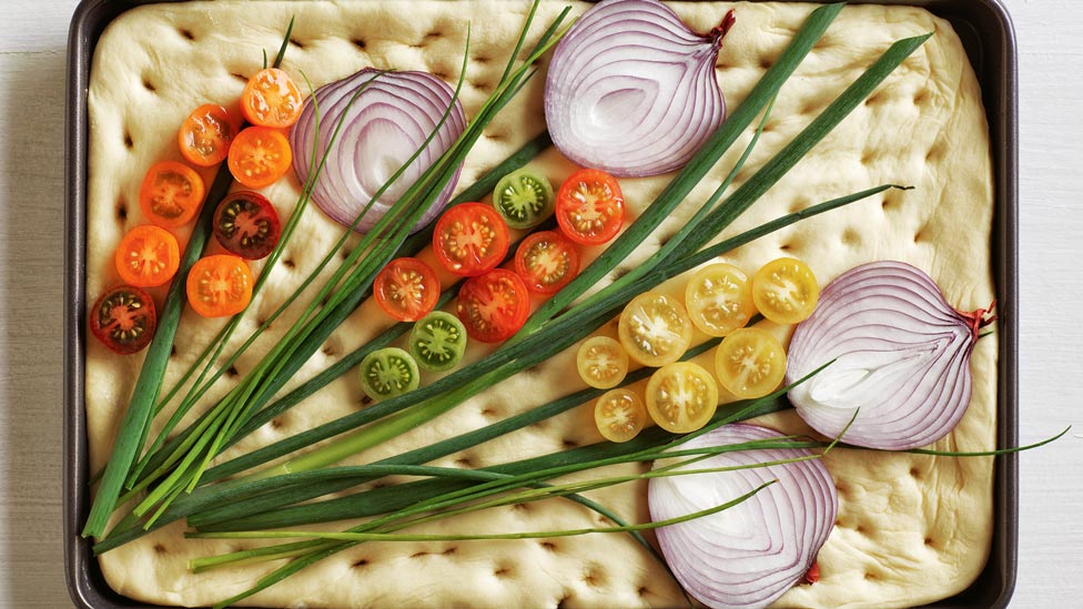 A focaccia with spring onion, red onion and tomoatoes