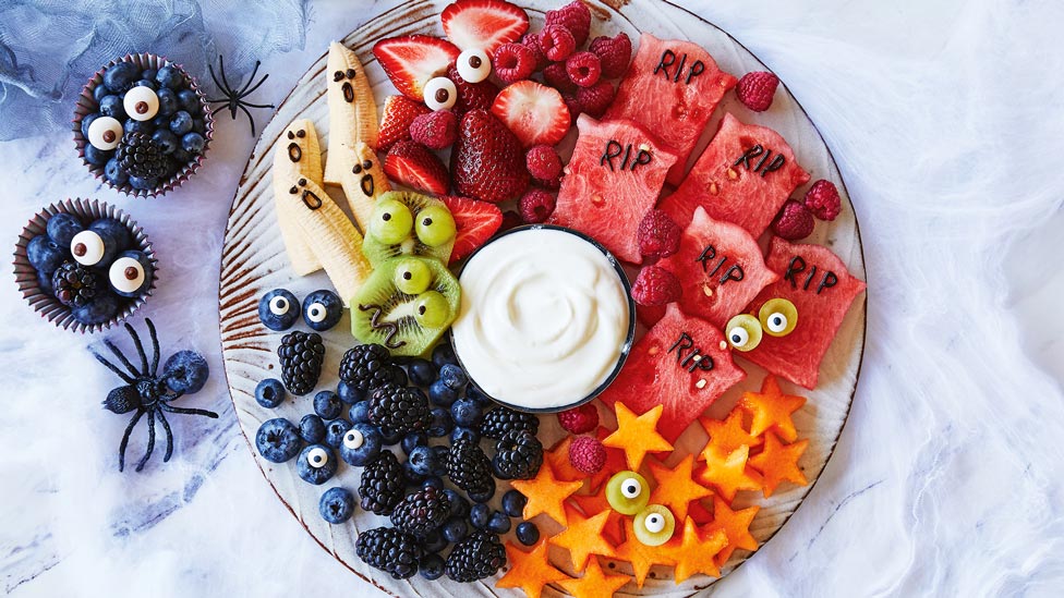Funny fruit platter with five different fruits and greek style yoghurt