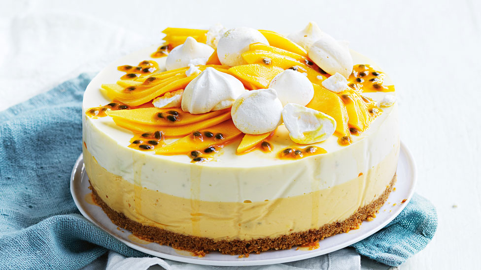 Layered mango and passionfruit cheesecake topped with meringues