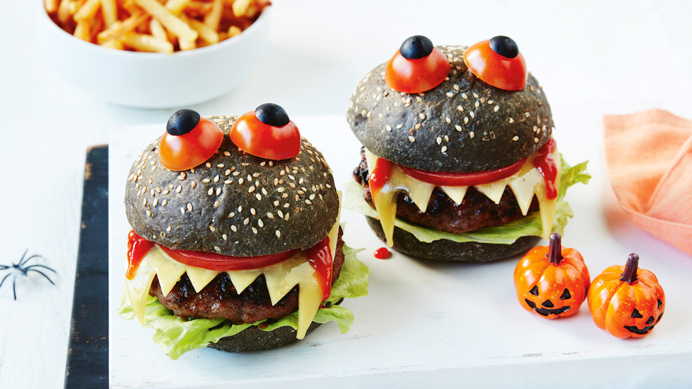 Two monster burgers decorated with tomato and blueberry