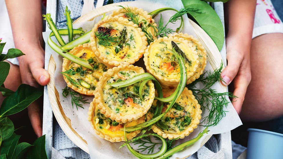 Five salmon and asparagus mini quiches on a plate
